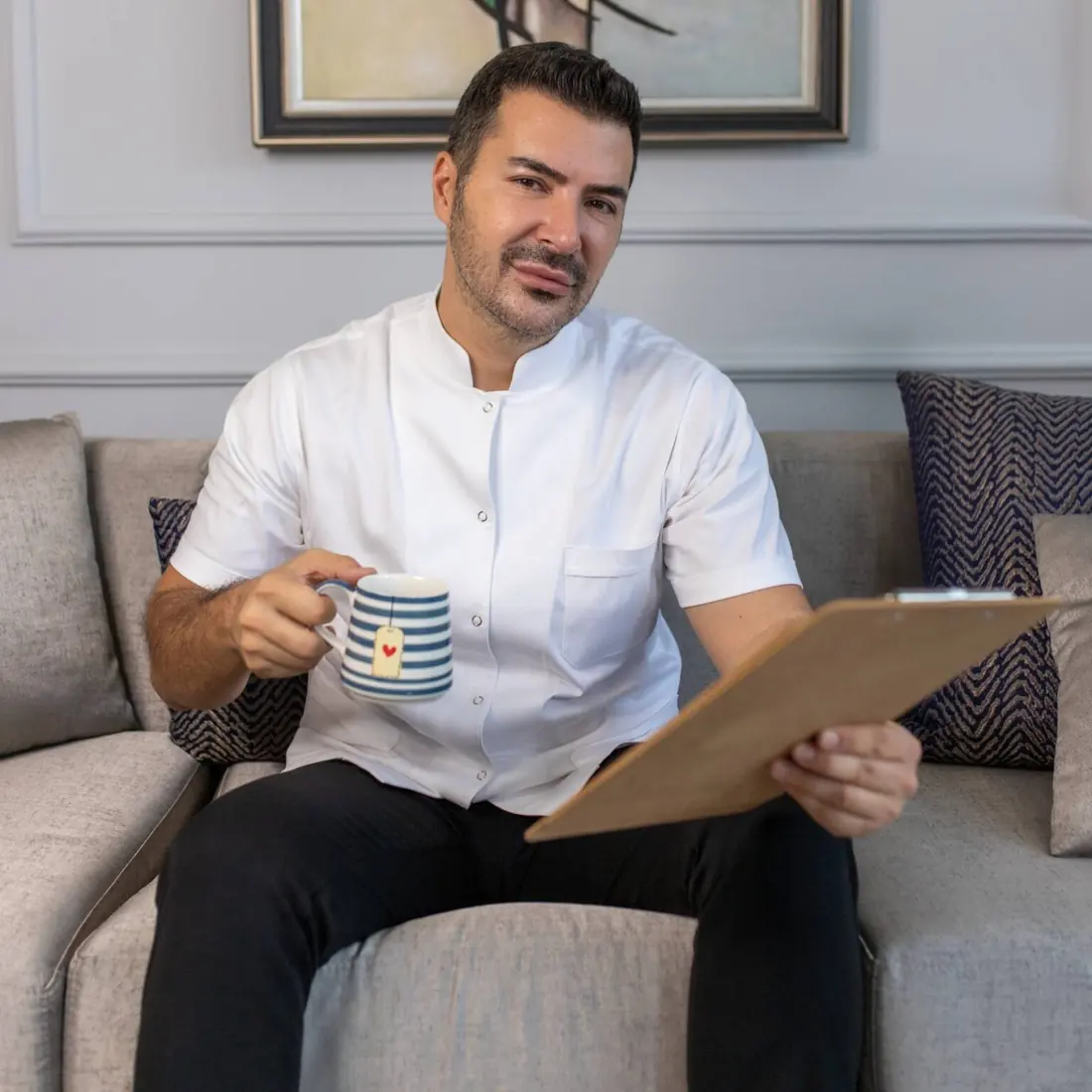 Doç. Dr. Çağrı Türker klinikte, elinde bir fincan çay
